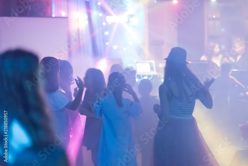 blur Light in club party Show And Silhouette hands of audience crowd people use smart phones enjoying the club party with concert. Blurry night club DJ party people enjoy of music dancing sound.
