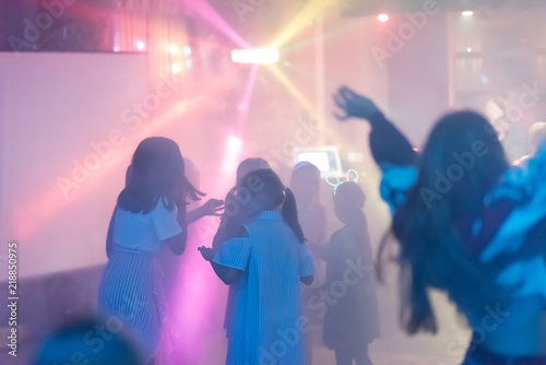 Fototapeta Naklejka Na Ścianę i Meble -  blur Light in club party Show And Silhouette hands of audience crowd people use smart phones enjoying the club party with concert. Blurry night club DJ party people enjoy of music dancing sound.