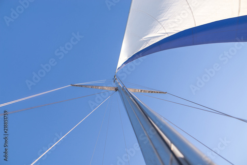 Blue sky and sail yacht look from the bottom. Yachting concept. Background. Walk on a sailing yacht by sea.