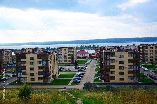 5floors houses street with parking cars against river