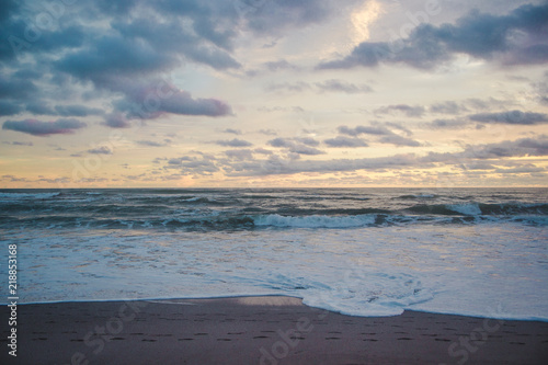 Fototapeta Naklejka Na Ścianę i Meble -  Horizon to shore waves at a cloudy, colourful sunset in Central America