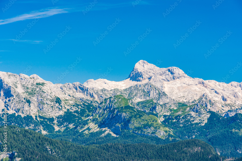 Triglav and Slovenia mountains landscape from Vogel. View of biggest Slovenia Julian alps. Travel and hiking in Europe. Summer sky and green nature
