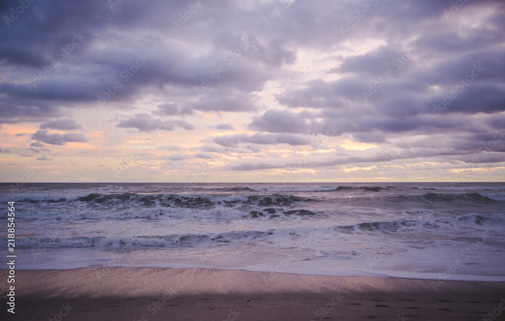 Horizon to shore waves at a cloudy, colourful sunset in Central America