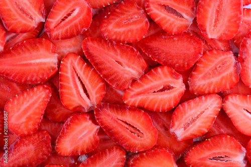 Fresh strawberry slice red background. Summer background texture of sliced strawberries.