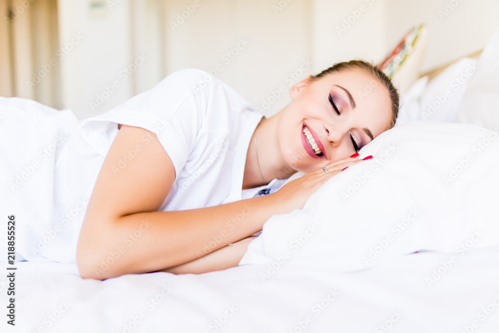 Beautiful young woman sleeping while lying in bed comfortably and blissfully. Sunbeam dawn on her face Beautiful young woman sleeping while lying in bed comfortably and blissfully. Sunbeam dawn on her face