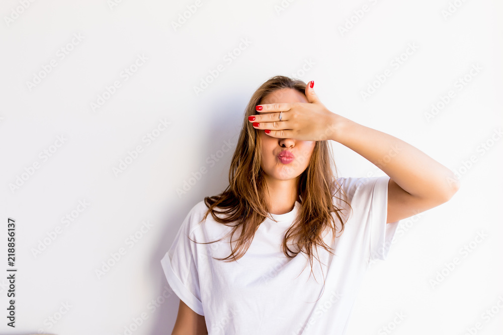 Young smile woman covering her eyes isolated on a white background Young smile woman covering her eyes isolated on a white background