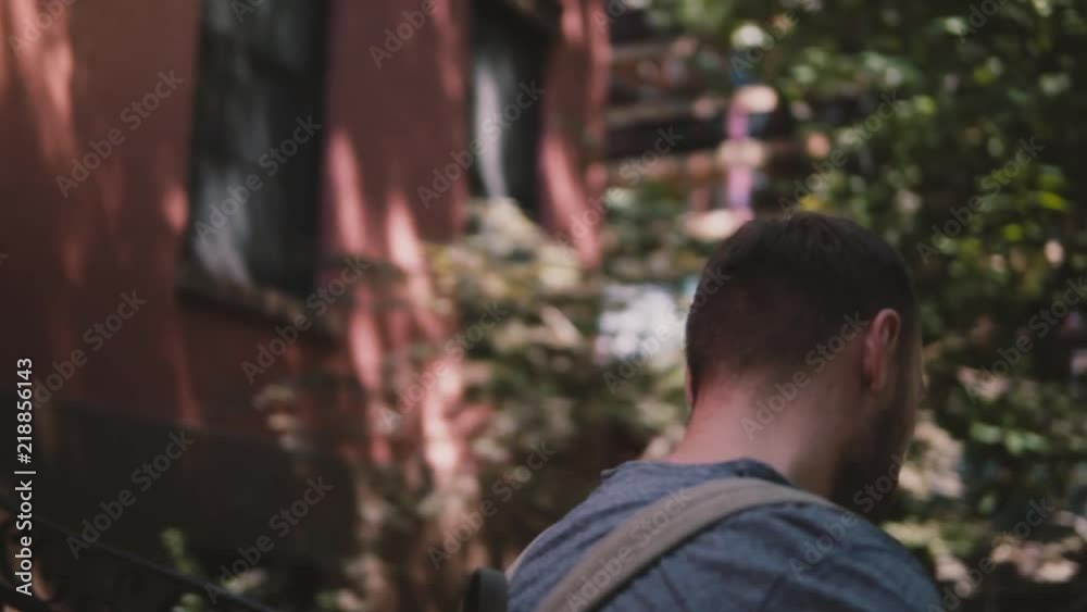Busy handsome European man walking down the stairs of a Brooklyn house with smartphone and coffee slow motion close-up. Busy handsome European man walking down the stairs of a Brooklyn house with smartphone and coffee slow motion close-up.