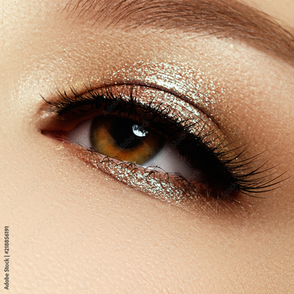 Close up of blue woman eye with beautiful brown with shades smokey eyes