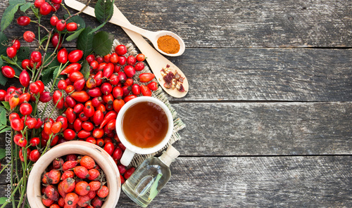 Foto Medicinal plants and herbs composition: Dog rose, bunch branch Rosehips, types Rosa canina hips, essential oil