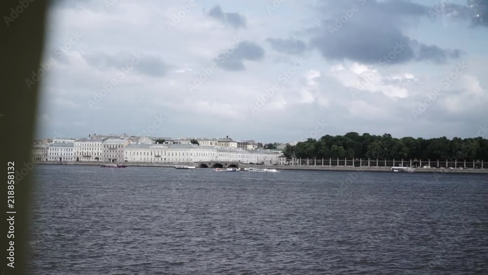 Passenger ships and river trams in city river at cloudy day. River Neva in Saint-Peterburg, view on Summer garden Passenger ships and river trams in city river at cloudy day. River Neva in Saint-Peterburg, view on Summer garden