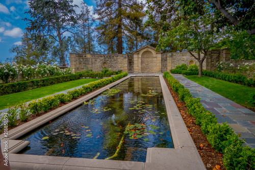 Outdoor view of Luxury House and estates with a beautiful artificial pond with acuatic plants as adorns in a back yard in Beverly Hills City, Los Angeles, CA