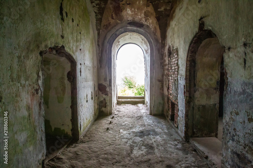 Abandoned building. Corridors in the old building. Shabby walls. Round doorways. © Grispb