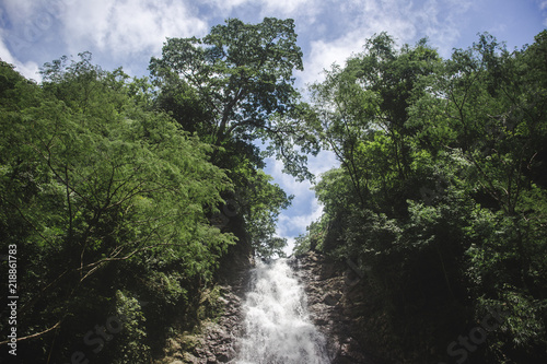 Water begins to fall from the top of Montezuma Waterfall  a popular tourist hike in Costa Rica