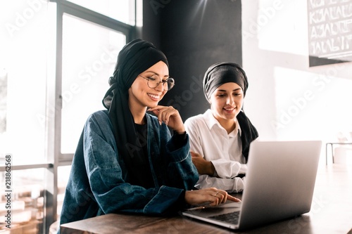 Muslim women hijab working at laptop sitting in office