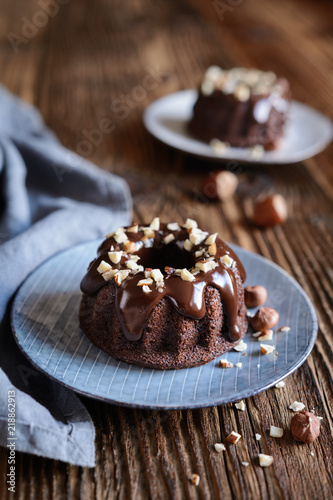 Mini chocolate bundt cakes topped with glaze and hazelnuts photo