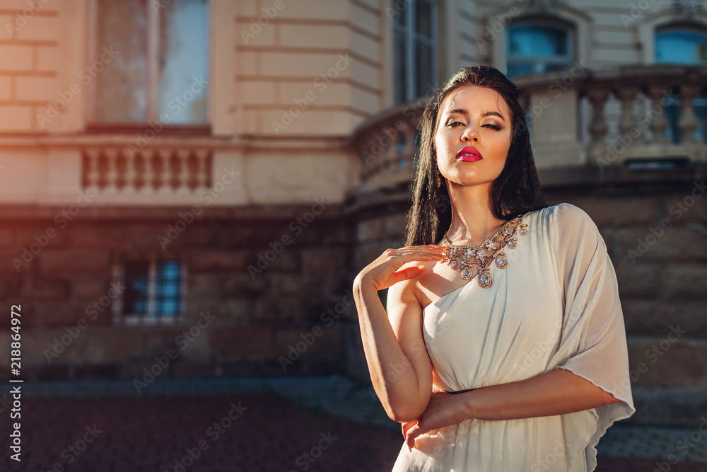 Beautiful woman wearing white wedding dress outdoors. One shoulder dress  with accessories and jewellery. Makeup Stock Photo | Adobe Stock