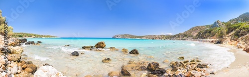 Beautiful colorful beach at Crete island, Greece. Voulisma paradise beach with rocks and mountains. Summer vacation travel holiday background concept.