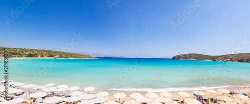 Beautiful colorful beach at Crete island  Greece. Voulisma paradise beach with umbrella and sunbeds.  Summer vacation travel holiday background concept.
