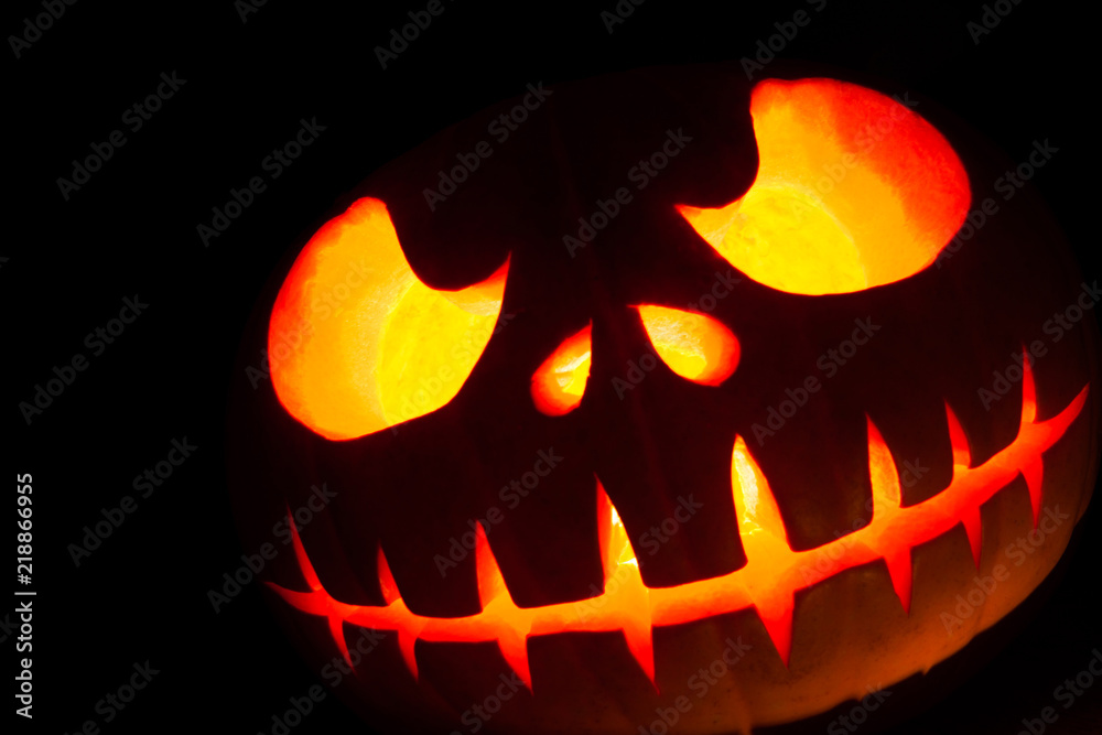 Fototapeta premium Ghastly Halloween pumpkin head jack lantern on black background