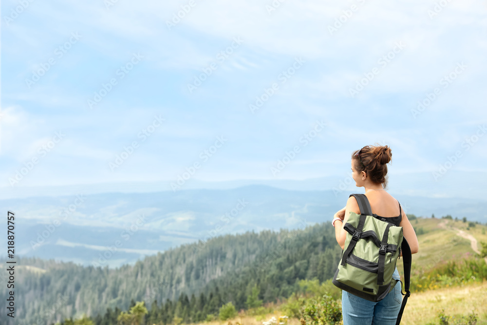 Woman with backpack in wilderness on cloudy day