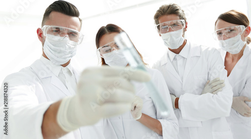 background image is a group of medical workers working with liquids in laboratory