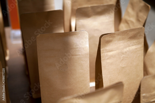 Group of brown kraft paper bags with air vent close-up. Blank retail coffee packaging with copy space