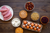 Healthy food. Products rich protein and fiber. Legumes, nuts, low-fat cheese, meet, eggs. Raw beans, chickpeas, lentil, almond, hazelnut on dark wooden background top view