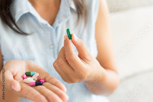 Woman hand with pills medicine tablets and capsule in her hands. Healthcare  medical supplements concept