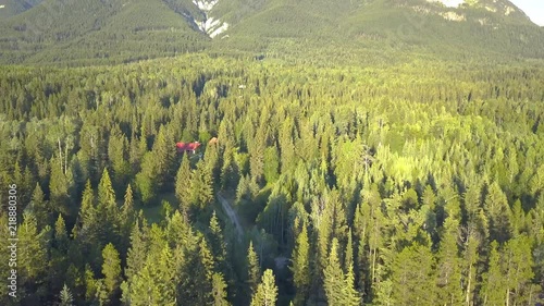 Mountain and forest aerial ending with a parked car photo