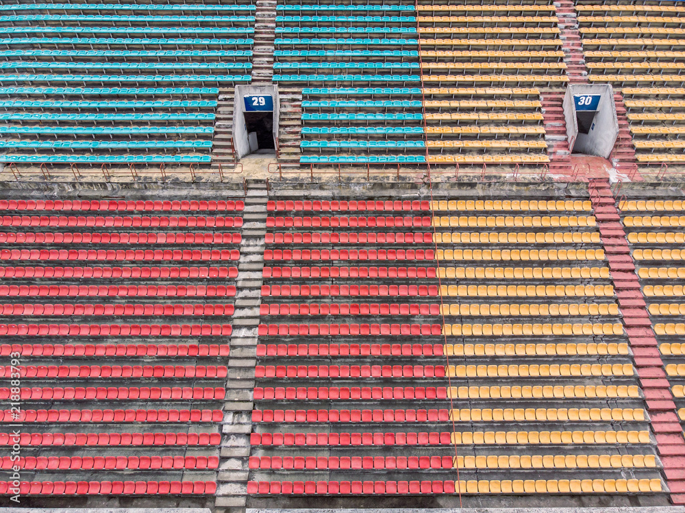 Fototapeta premium empty colorful plastic chairs in row at the football stadium. aerial view 