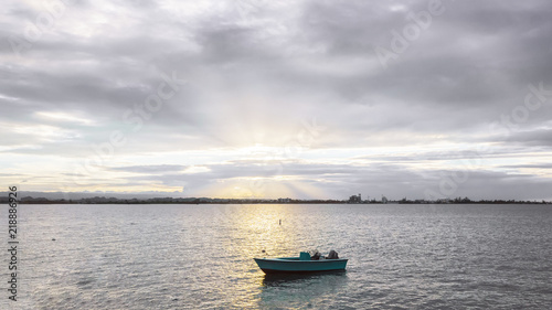 Boat on the Sea against Sunset and Cloudy Sky