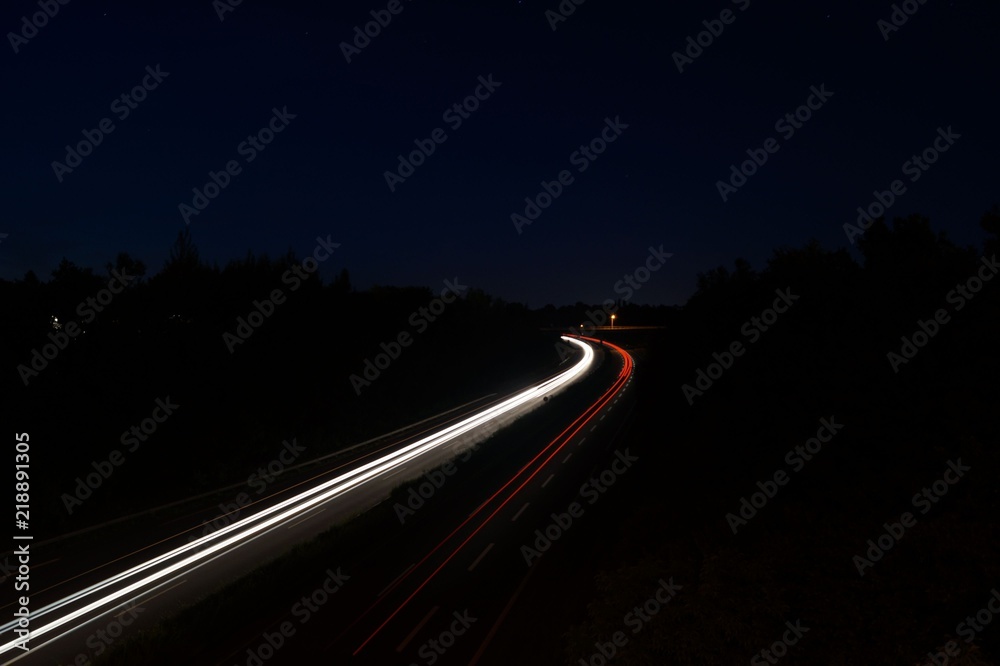Automobile light trails, night highway traffic, city landscape. Picture taken with long exposure shooting
