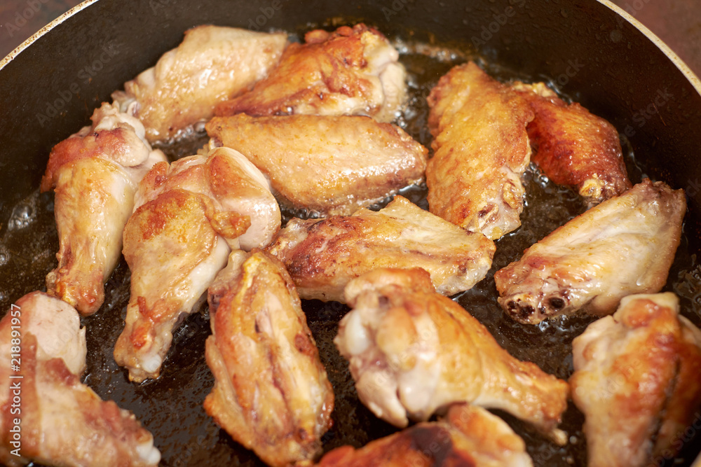 Fototapeta premium Chicken wings fried in pan with hot oil, homemade food