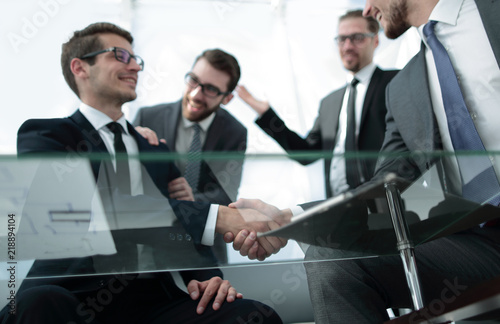 bottom view.business partners shaking hands sitting at the Desk