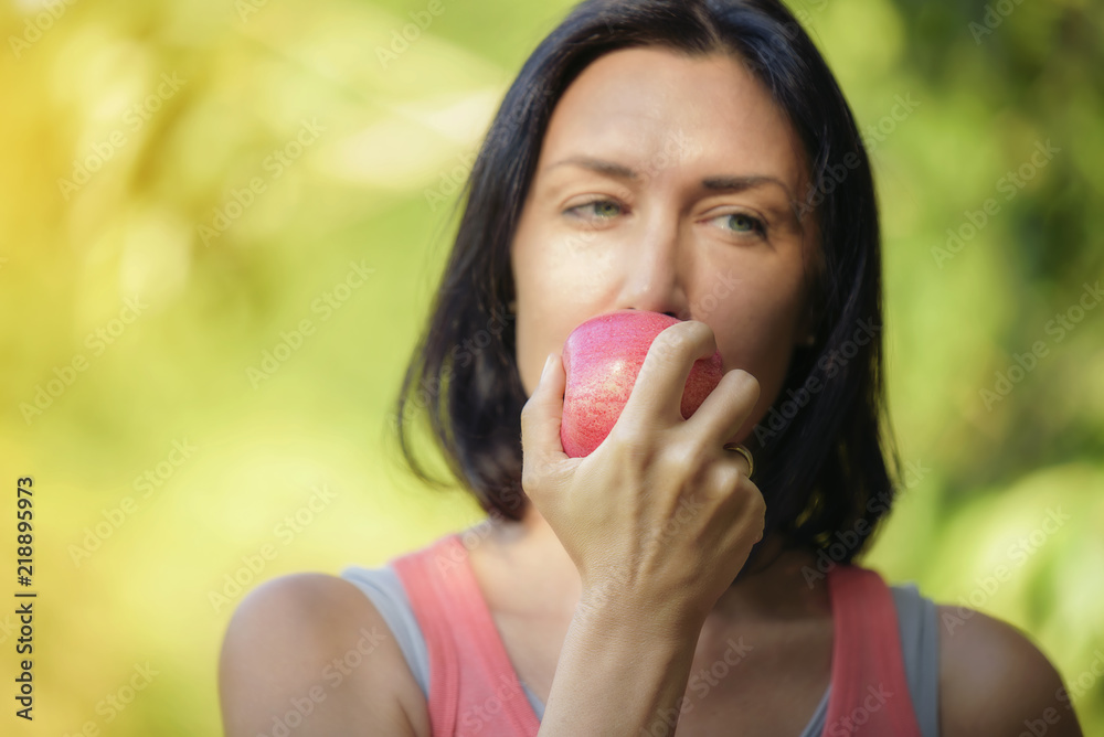 Older woman is eating apple after exercising to take care of their health.Eat healthy eating concept.Focus on the hand that holds the apple. Older woman is eating apple after exercising to take care of their health.Eat healthy eating concept.Focus on the hand that holds the apple.