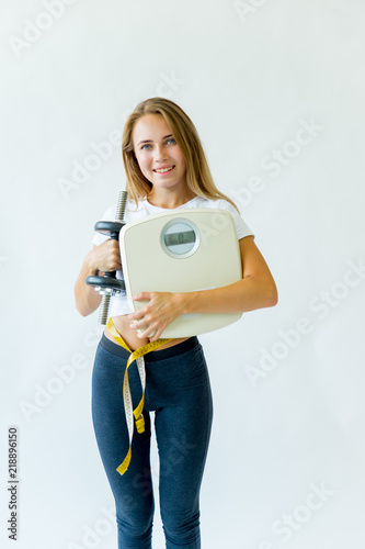 Fit woman measuring waist with measuring tape