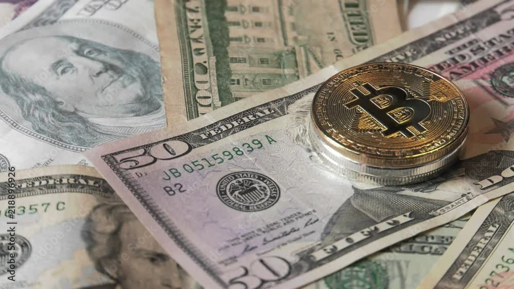 Physical metal Bitcoin currency over dollar bills. Virtual internet money with US banknotes. Digital coin cyberspace, cryptocurrency. BTC golden coin as symbol of electronic virtual money. Physical metal Bitcoin currency over dollar bills. Virtual internet money with US banknotes. Digital coin cyberspace, cryptocurrency. BTC golden coin as symbol of electronic virtual money.