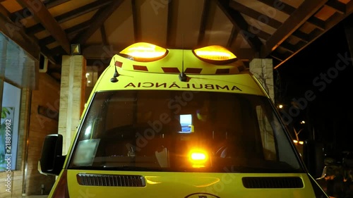 Ambulance with Flashing Siren Lights Parked By Emergency Department photo