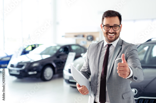 Photography Successful businessman in a car dealership - sale of vehicles to customers