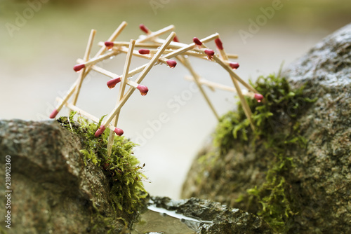 self-supporting bridge by leonardo da vinci built from matches over mossy rocks photo
