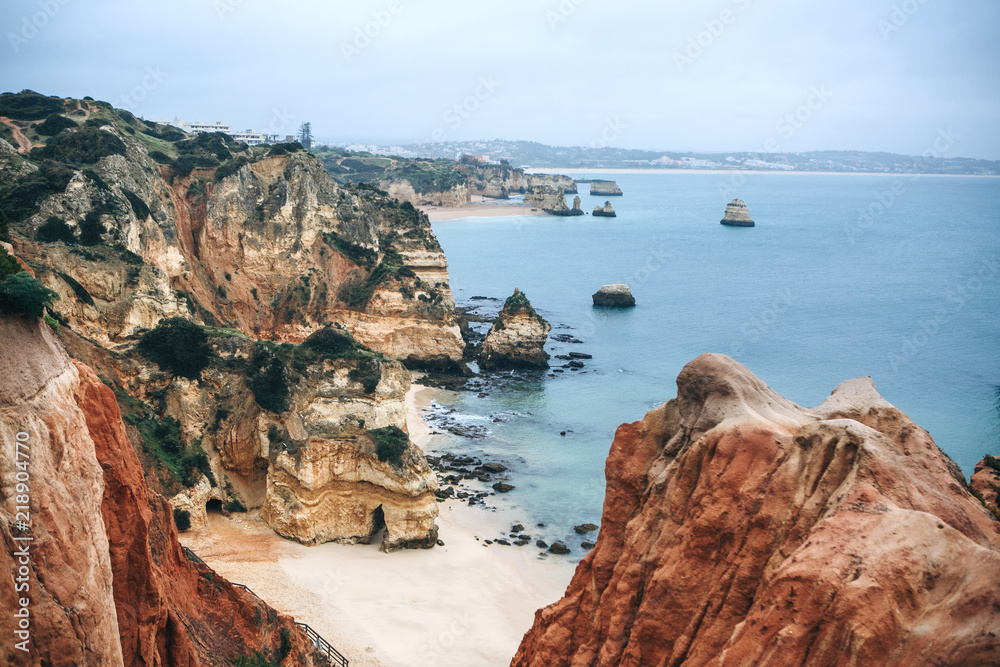 Obraz premium A view of the beautiful beach and rocks and the Atlantic Ocean off the coast of Portugal next to the city called Lagos.