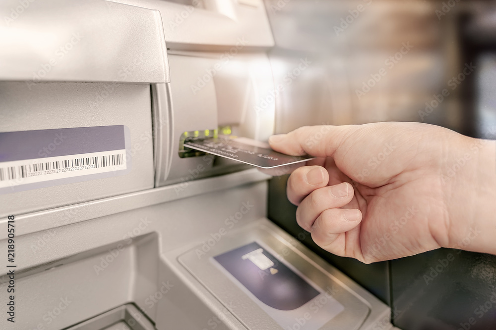 Man is inserting card to atm machine Man is inserting card to atm machine