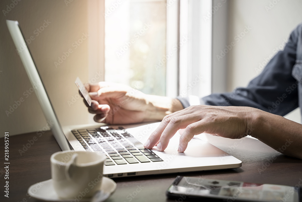 man using laptop and holding credit card to buying online at home man using laptop and holding credit card to buying online at home