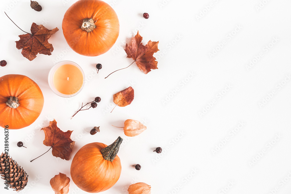 Fototapeta Jesienna kompozycja. Dynie, świece, suszone liście na białym tle. Jesień, jesień, koncepcja halloween. Płaski układanie, widok z góry, kopia przestrzeń