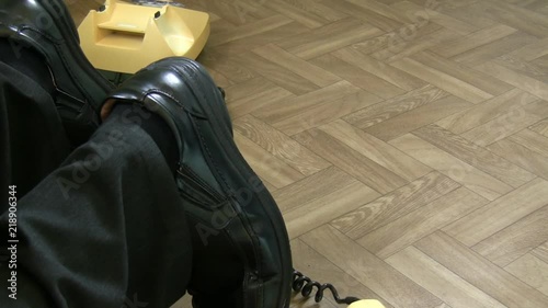 Accident, health and safety hazard concept. Legs of man tripping over hanging old rotary telephone cable or wire in the office or room