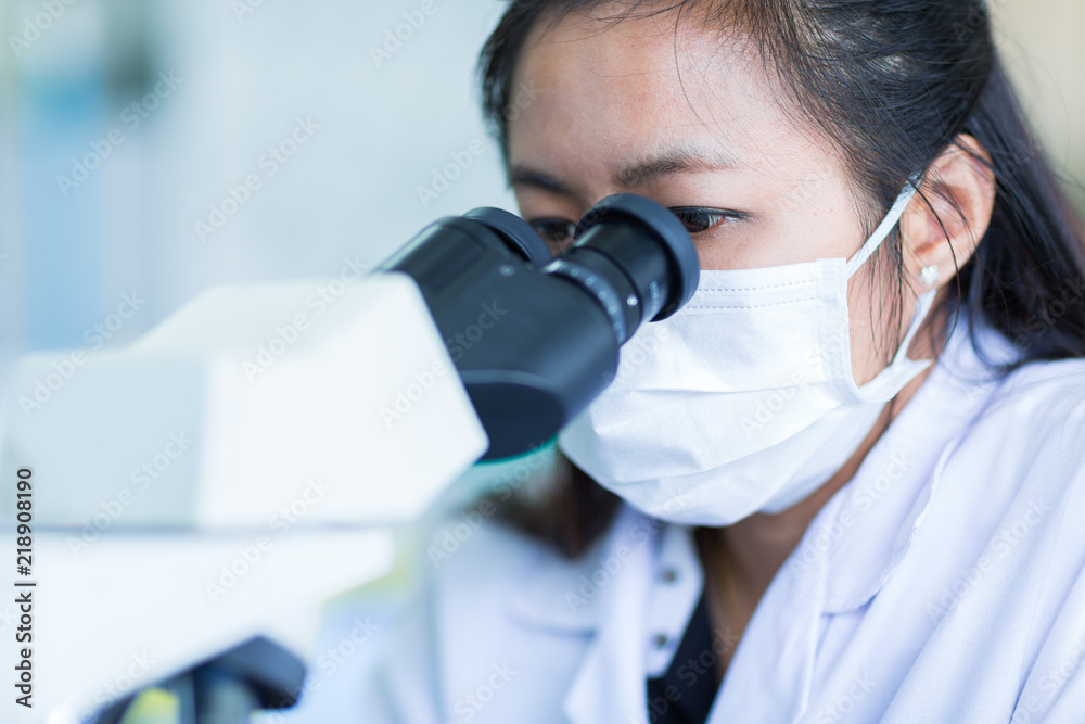 Scientist using a microscope in a laboratory Scientist using a microscope in a laboratory