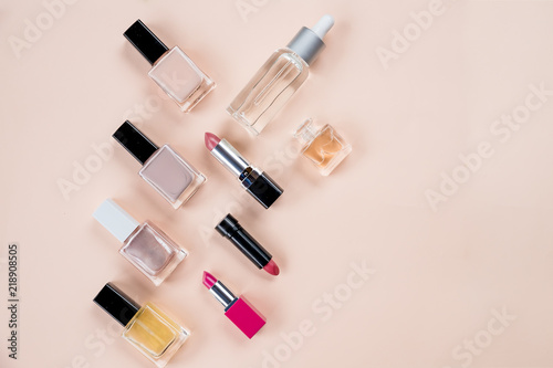 Colorful frame with various makeup products on pastel background. cosmetics, skin care, perfume, nail Polish, lipstick flat lay and skin oil bottle over a beige background.Beauty products concept.Copy