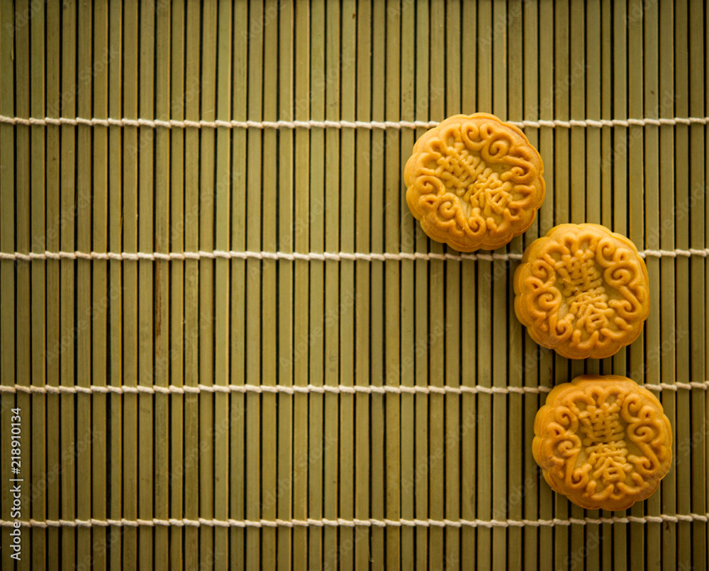 Mooncakes on bamboo mat dark light with copy space Mooncakes on bamboo mat dark light with copy space