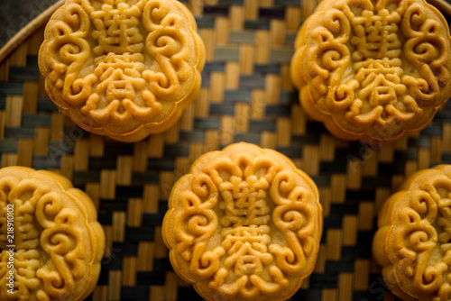 Mooncakes on bamboo background dark light