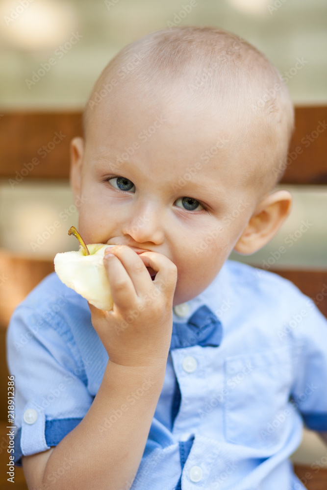 Portrait Of Baby Boy Eating green Apple. Active Cute boy eating green apple. Portrait Of Baby Boy Eating green Apple. Active Cute boy eating green apple.